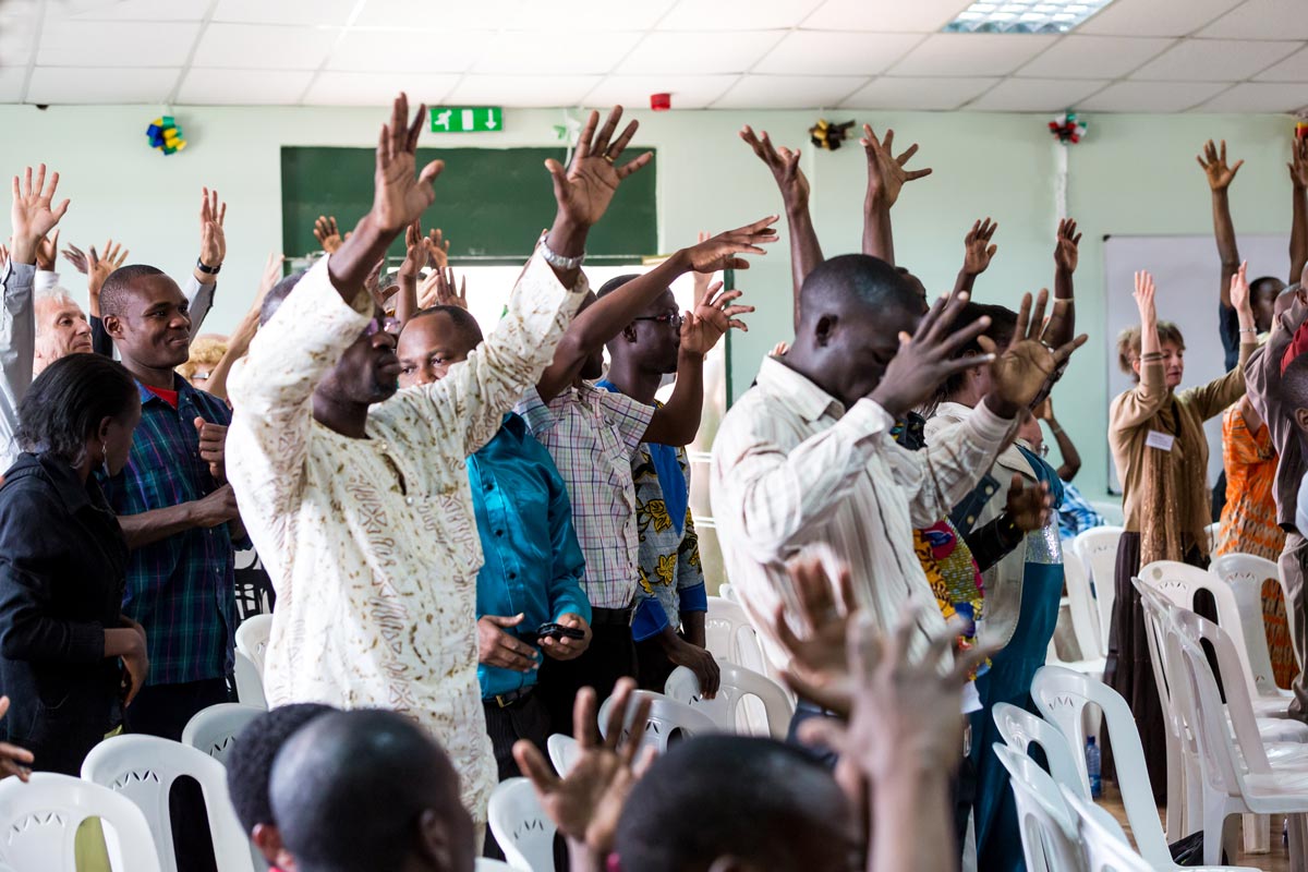 Kenya - people worshipping with hands raised